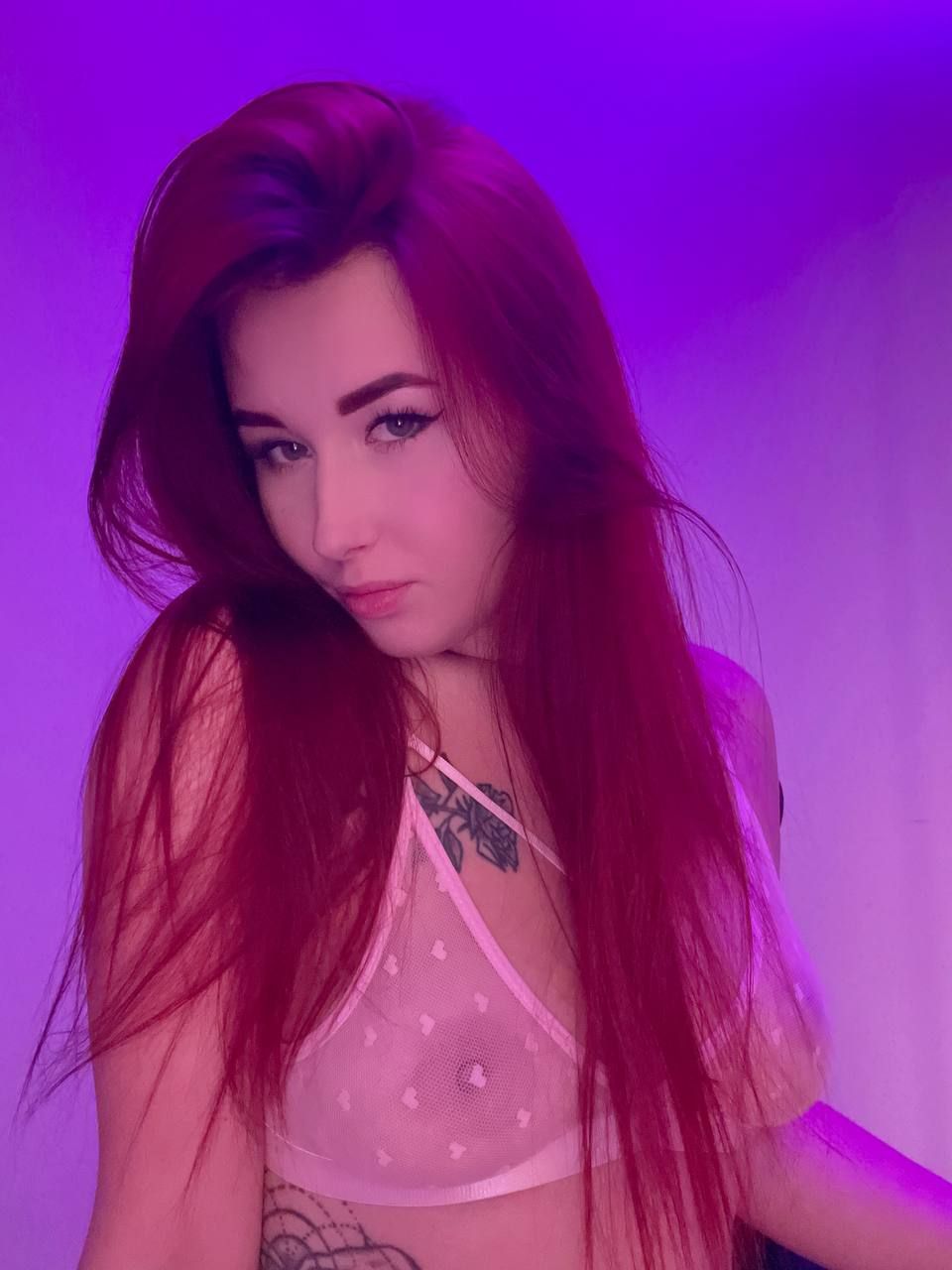 angel_rainbow_peach wearing a pink see-through bra looking seductively at the camara