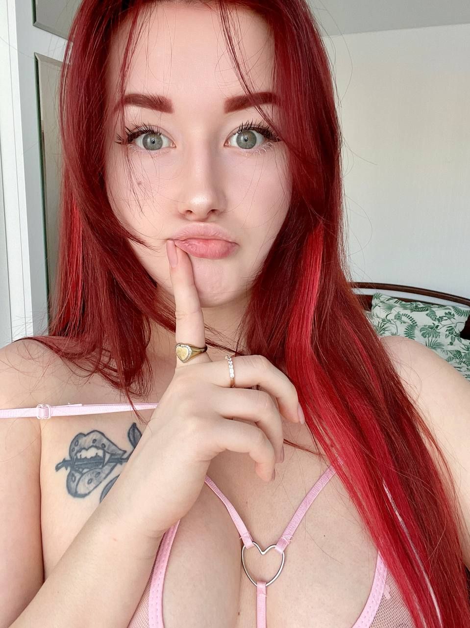 angel_rainbow_peach making a selfie face, wearing a pink see-through bra